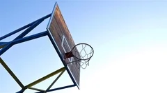 Low angle time lapse of basketball hoop enlightened by the morning sun