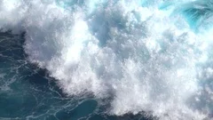 SLOW MOTION Big barreling foamy ocean wave crashing into the rocky reef on beach