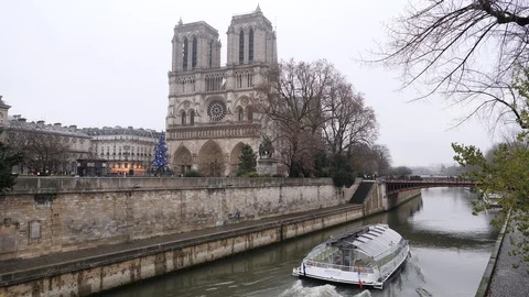 08 Rainy gray winter day Paris Notre Dame cathedral building and river bus go Stock Footage 100814651