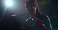 Young female boxer getting ready for a night fight