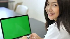 4K : Happy Asian business woman typing on a laptop computer with green screen