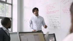 Businessman talking near whiteboard in meeting