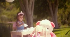 Little Asian girl playing tea party with her toys