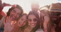 Young multi-ethnic hipster friends having fun video-calling at the beach