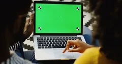 African American couple scrolling on the laptop computer with green screen and