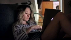 Tired woman on sofa night working on notebook.Sleepy woman using laptop