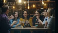 Diverse Group of Young People Have Fun in Bar, Talking, Telling Stories and Joke