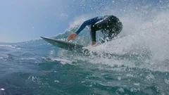 SLOW MOTION, LOW ANGLE Young man surfing big crashing ocean wave in sunny nature