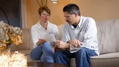 Middle Aged couple is upset about a fee increase on financial statement