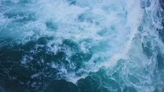 Top view of ocean blue waves crashing coastline cliff drone footage