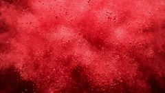 Red powder/particles fly after being exploded. Slow Motion.