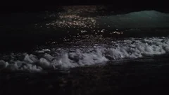 Night view of the dark sea waves rolling in on the shore