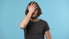 Portrait of annoyed bearded man covering face like facepalm expressing