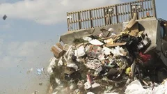 Slow Motion Shot of a Bulldozer Moving Trash in a Garbage Dump / Landfill
