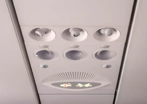 Adjustable  lights  and  air  conditioners  overhead  seat  controls  of  a  commercial  aircraft  in  an  airplane  with  no-smoking  and  seat  belt  on  signs xkwx nobody,  part,  transport,  inside,  air,  travel,  transportation,  panel,  fly,  flight,  console,  airplane,  conditioner,  sign,  cabin,  aircraft,  plane,  light,  overhead,  control,  aviation,  conditioning,  board,  button,  lamp,  cool,  seat,  jet,  ventilation,  closeup,  vent,  smoke,  ceiling,  seating,  safety,  warning,  no,  plastic,  aeroplane,  airline,  knob,  detail,  round,  symbol,  commuter,  security,  passenger,  airliner,  background