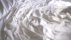 A background texture of soft white fabric textile material reverse moving.