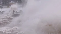 Massive waves crash into shore in typhoon and hurricane force wind storm