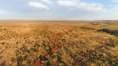 Aerial view flying over dirt road winding through the Australian desert