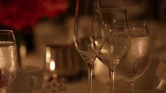 Glasses reflect Candlelight at a fancy dinner table