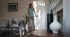 Millennial Female Arriving Home with Husky Dog Uses Alexa Smart Home Device