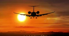 Airplane landing - private jet silhouette on sunset