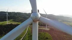 closeup aerial view of wind turbine blades rotating around with beautiful green