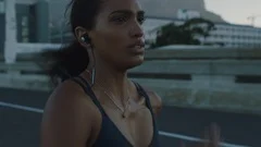 fit mixed race woman running on urban city road at sunrise training intense