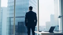 Businessman Looking out of Office Window on Big City
