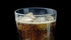 Coke Pours Into Glass With Ice Cubes