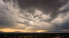 Time lapse of dramatic clouds rolling over city landscape