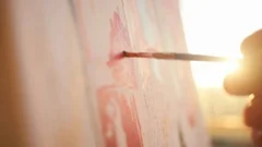 Slow motion close up artist woman hand hold brush painting picture on canvas in