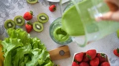 Pouring Freshly Blended Green Fruit Smoothie In A Glass