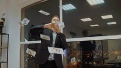 Rich business man throwing out money from stack on office window background