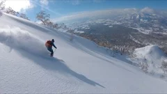 DRONE: Freestyle skier shredding the snow while riding in the scenic mountains.