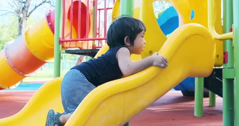 1-2 year old boy play in colorful playground with slider and bike park Stock Footage 133249143
