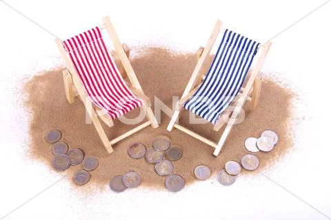 1 and 2 euro coins lie in front of toy beach chairs Stock Illustration