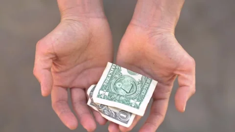 A $1 bill falls into open palms. Stock Footage 266912967