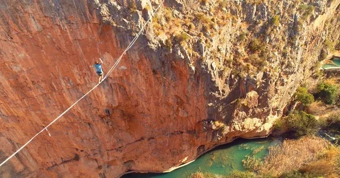 1 Brave Man Slacklining , highlining above a big canyon  Stock Footage 85265947
