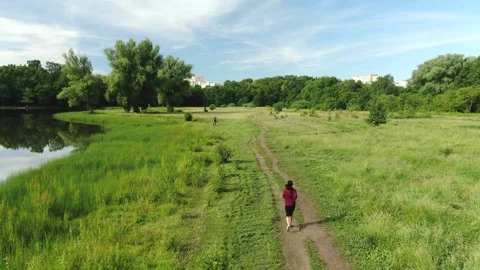 1 flying a drone over a field, lawn mower, road in a field, forest, woman ru Stock Footage 267403900