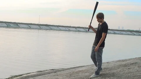 1 guy with bat in hand go. One man hit bat through air. Stock Footage 72643305