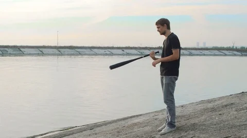 1 guy with bat in hand go. One man hit bat through air. Stock Footage 72643424