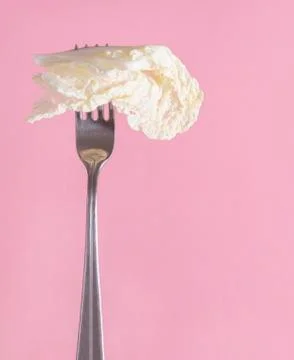 1 lettuce leaf on a fork on a pink background Stock-Fotos