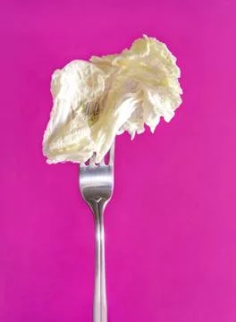 1 light lettuce leaf on a fork on a  violet background Foto stock