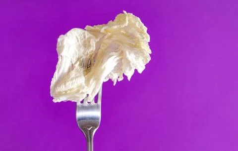 1 light lettuce leaf on a fork on a lilac background Stock Photos