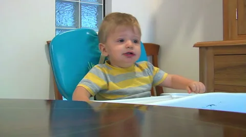 1 year old boy feeding in high chair Video stock 1060381