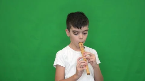 10 brunette boy in a white jacket plays the recorder Stock Footage 266700768