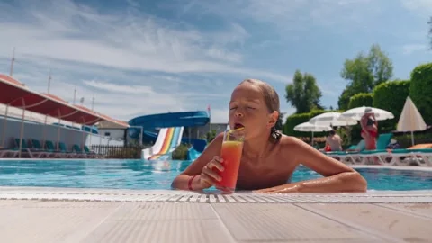 10 year old boy enjoying his holiday at the hotel. Drinking a cocktail in the Stock Footage 278971191