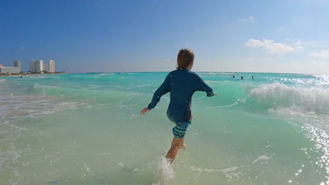 10 year old boy having fun on a Caribbean sea beach. Happy child playing by the Stock Footage 345005515
