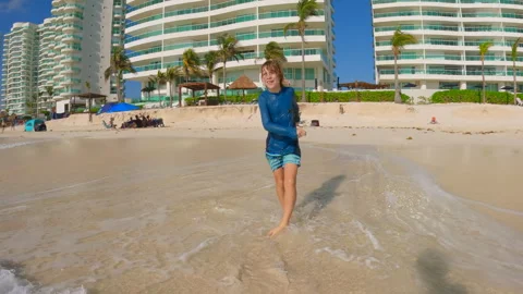 10 year old boy having fun on a Caribbean sea beach. Happy child playing by the Stock Footage 345006045