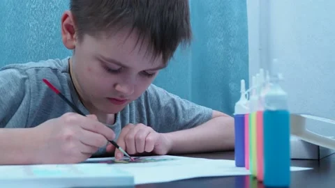 A 10-year-old boy paints with a brush. school of the arts. educational Stock Footage 145540109